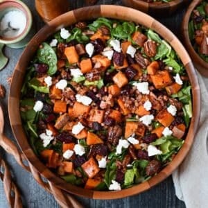 close up photo of beet and sweet potato salad in a wooden serving bowl