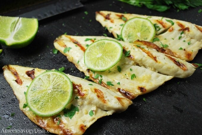 Side view of grilled Sea Bass with fresh lime