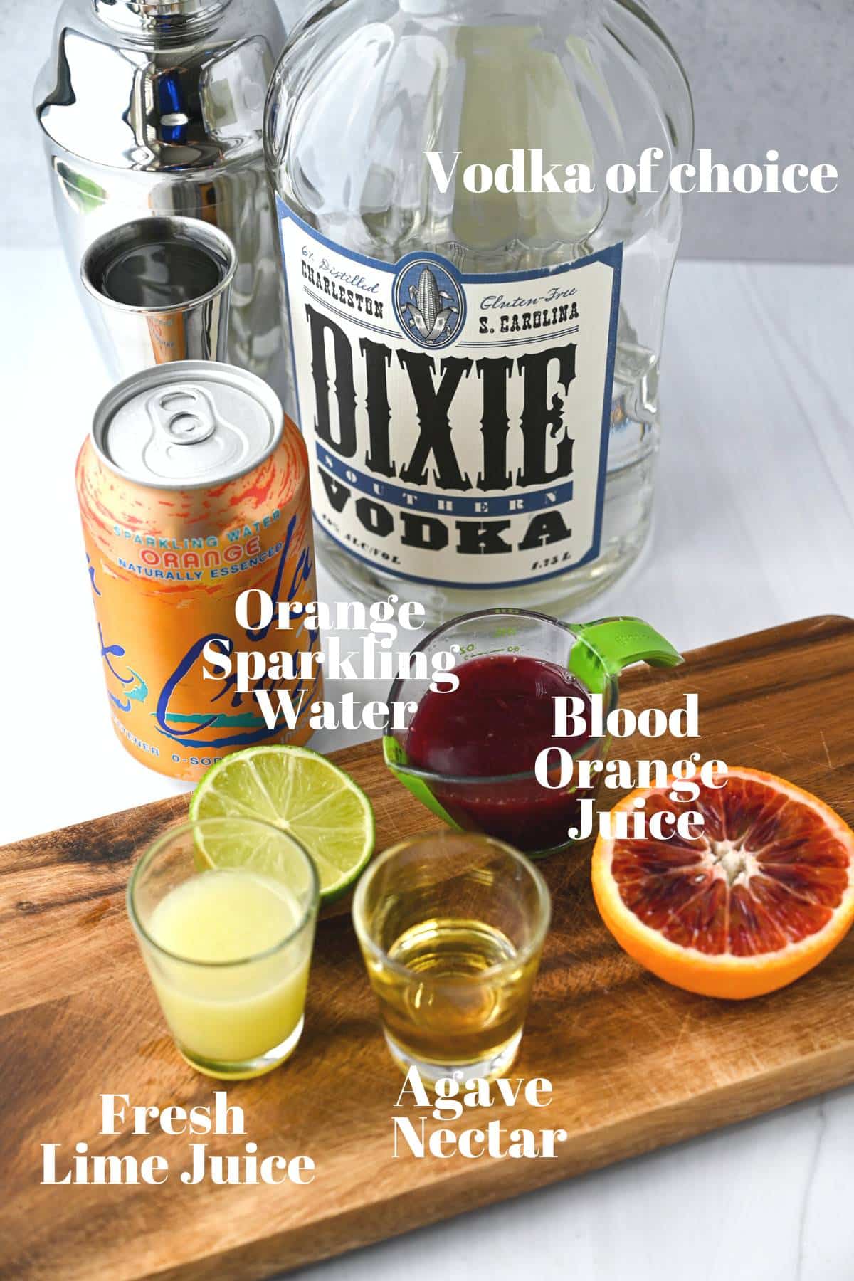 ingredients for a blood orange cocktail with vodka on a counter