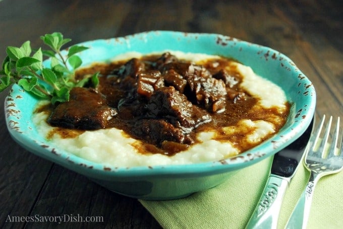 A close-up of a bowl of Mediterranean beef over cauliflower rice in a blue bowl