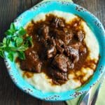picture of a bowl of Mediterranean beef with gravy over mashed cauliflower