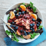 Blueberry and Salmon salad in a bowl with a blue napkin underneath