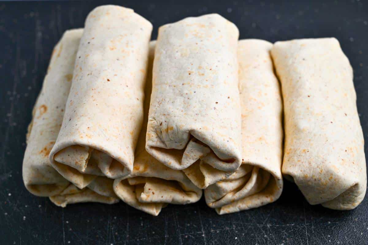 steak and egg burritos on a cutting board