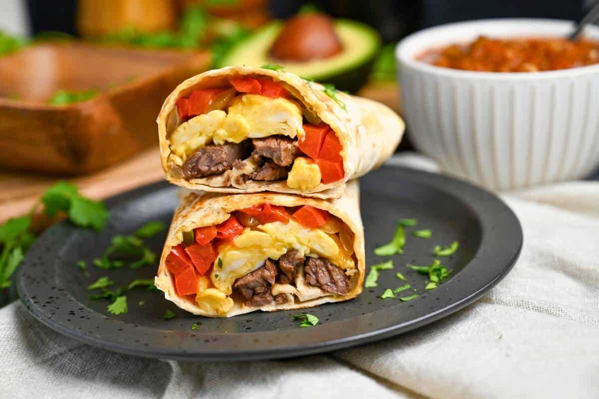 stacked steak and egg burrito on a plate 