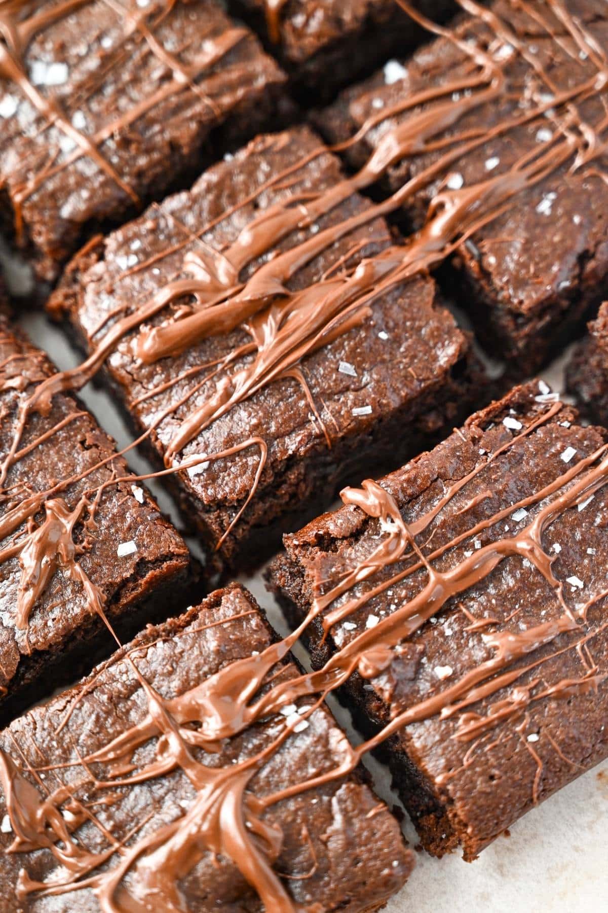 sliced brownies drizzled in chocolate with flaked salt on top