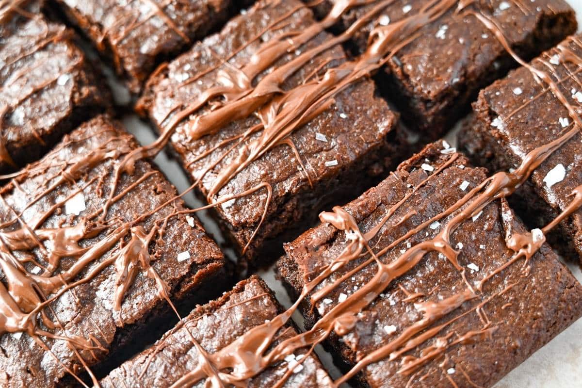 looking down at sliced brownies with melted chocolate chips drizzled on top