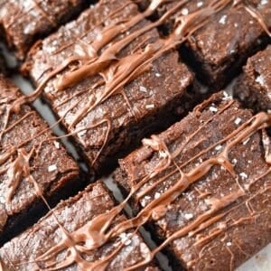 looking down at sliced tahini brownies with melted chocolate and flaked sea salt