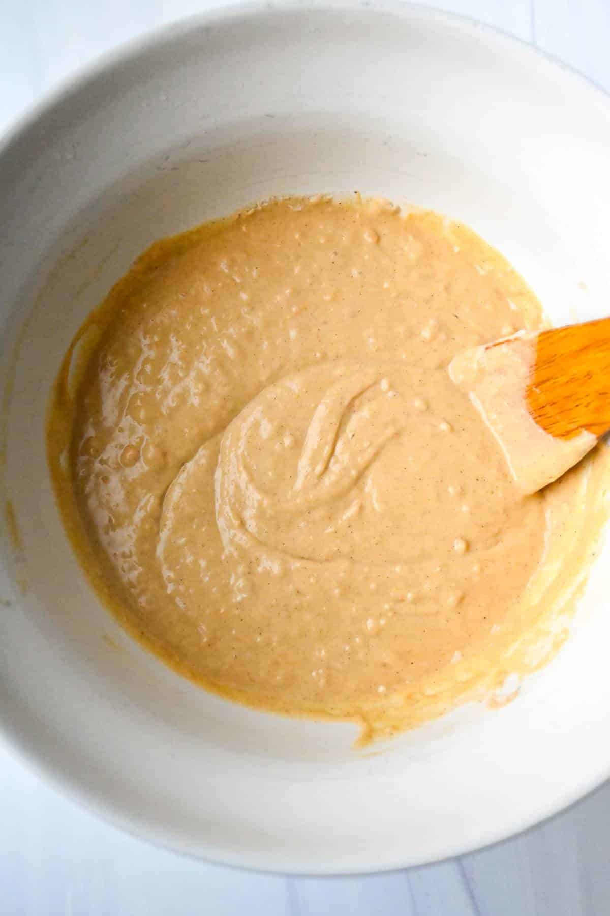 sweet potato pancake batter in a bowl with a spoon