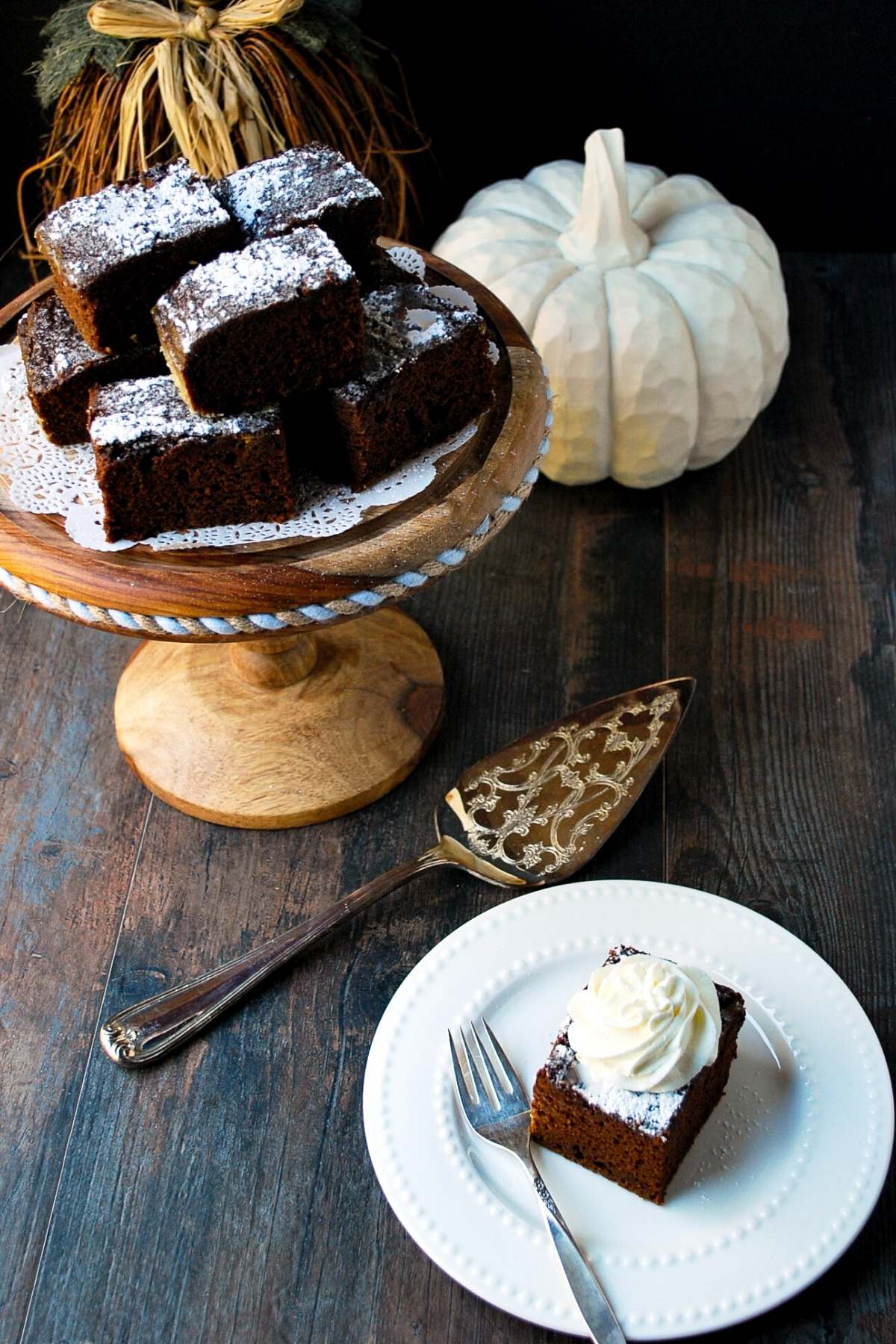 a platter of slices of pumpkin chocolate cake with a slice of cake on a plate with a fork next to it 