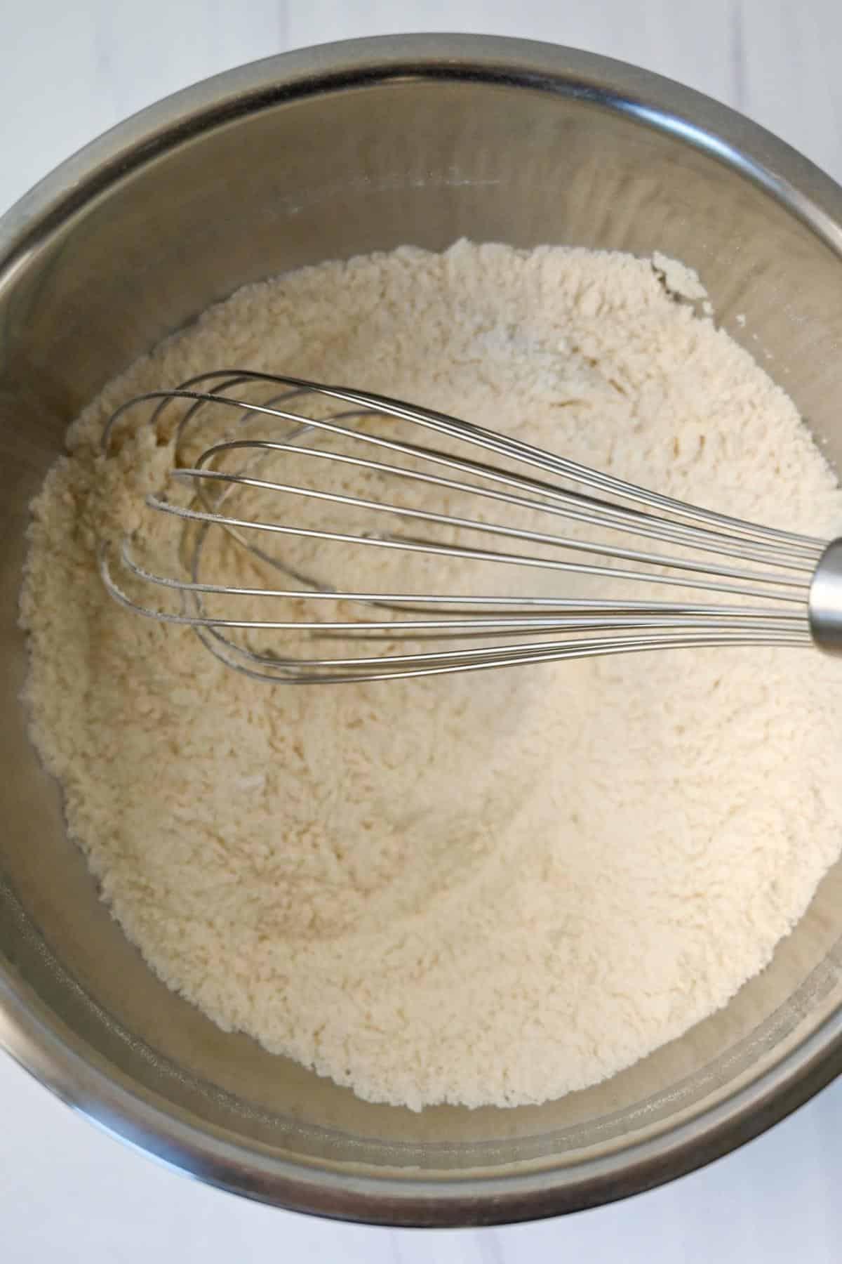 flour in a bowl with a whisk