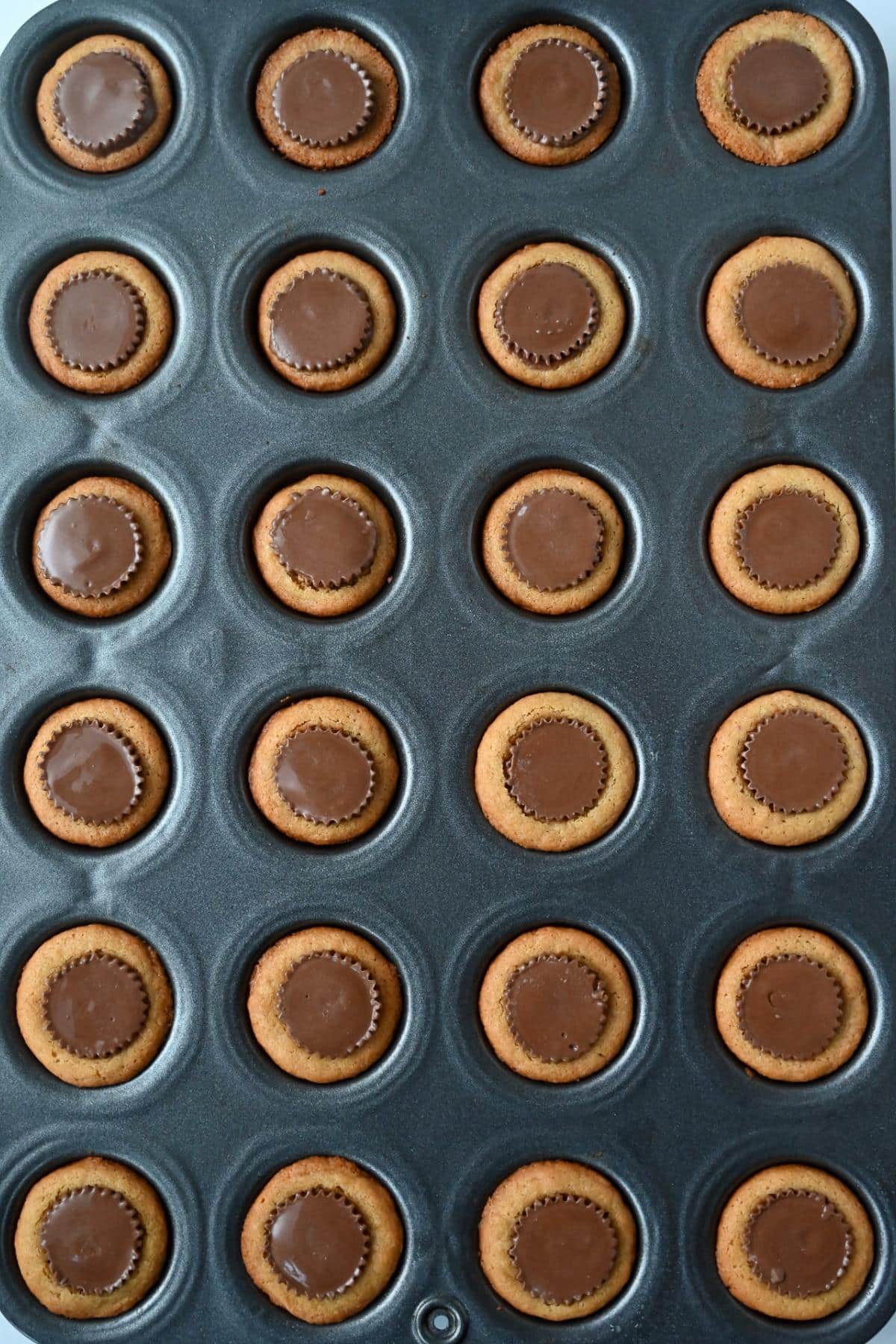 Reese's cookie tarts in a muffin tin with pb cups in the center