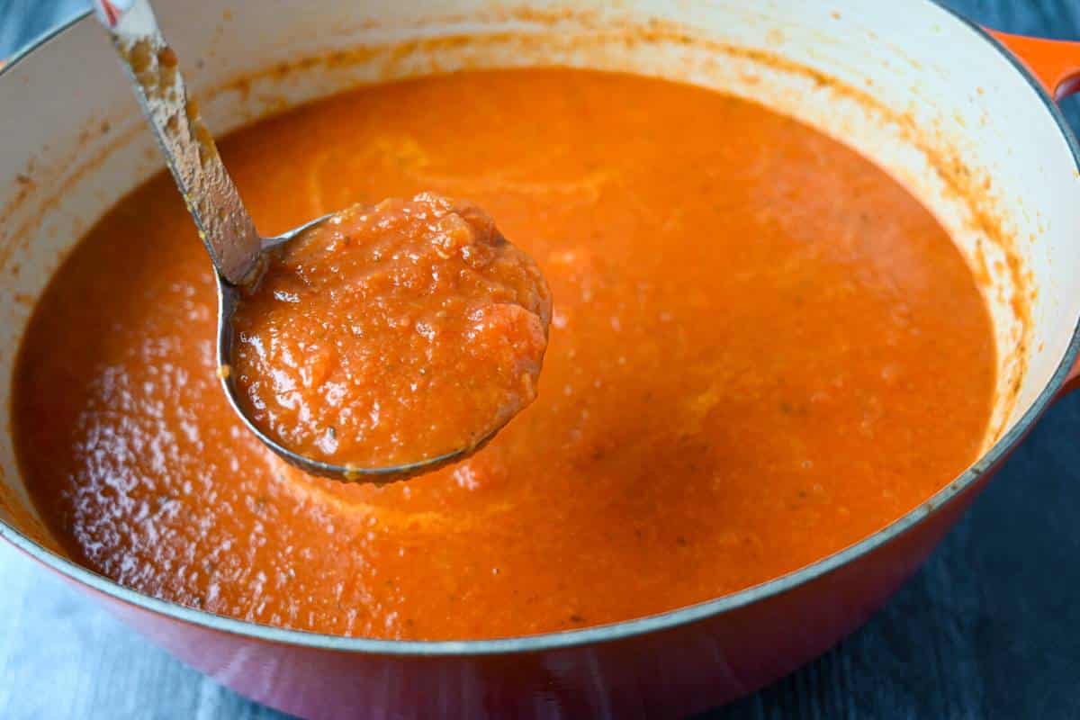 pureed tomato bisque with a ladle for serving