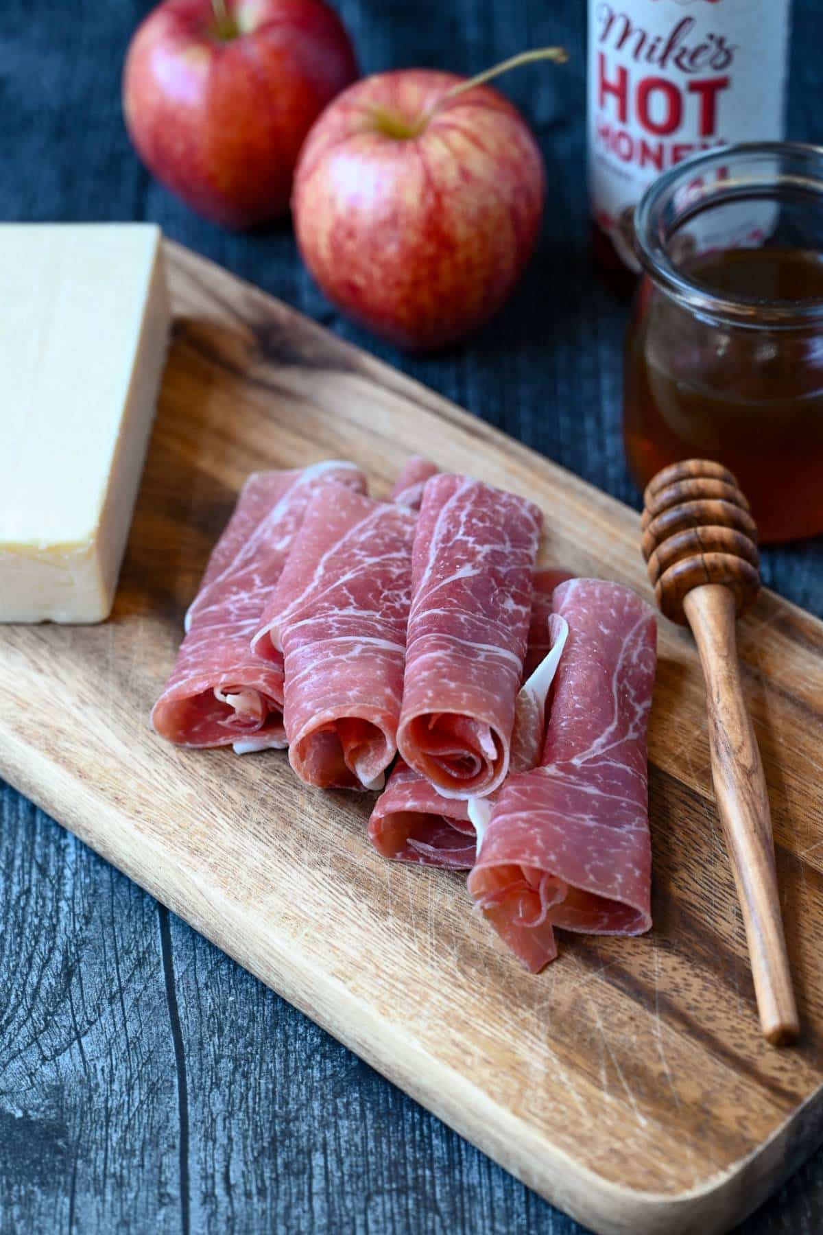 ingredients needed for prosciutto apple cheese bites on a cutting board