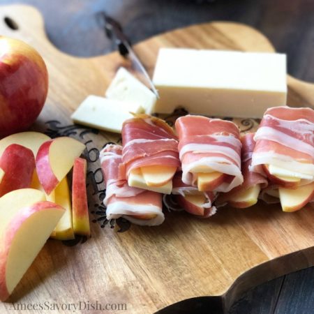 Food on a wooden cutting board, with Apple and Prosciutto