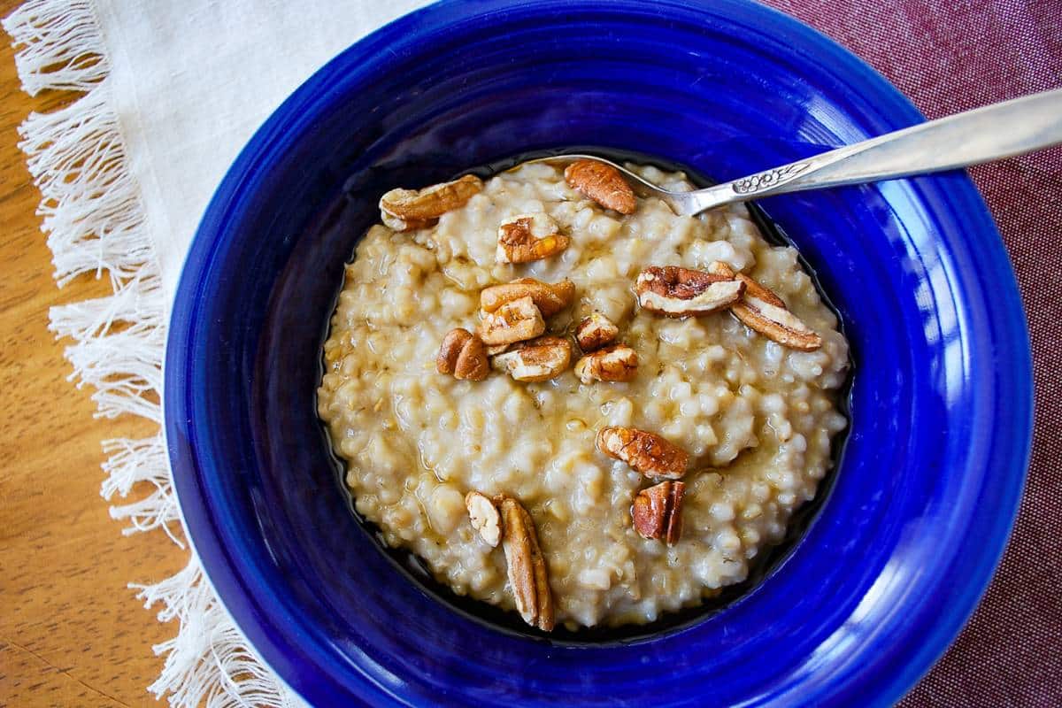a bowl of maple pecan topped steel cut oats that were prepared in an instant pot with a napkin underneath