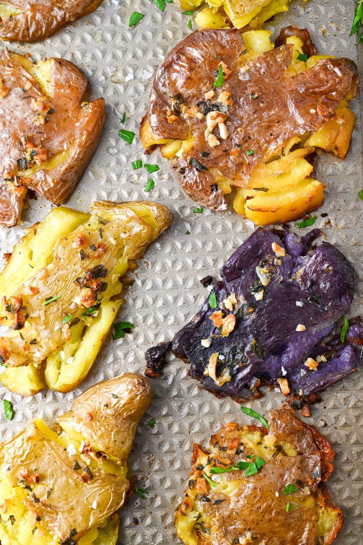 purple, red, and yellow roasted smashed fingerlings on a baking sheet