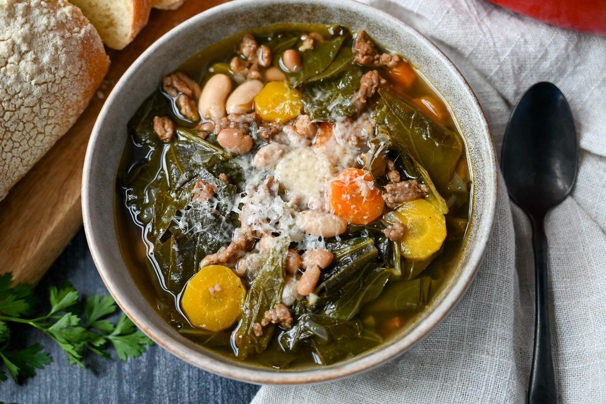 close up of a bowl of collard soup topped with fresh parm