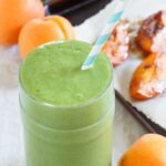 a roasted apricot smoothie with greens in a glass