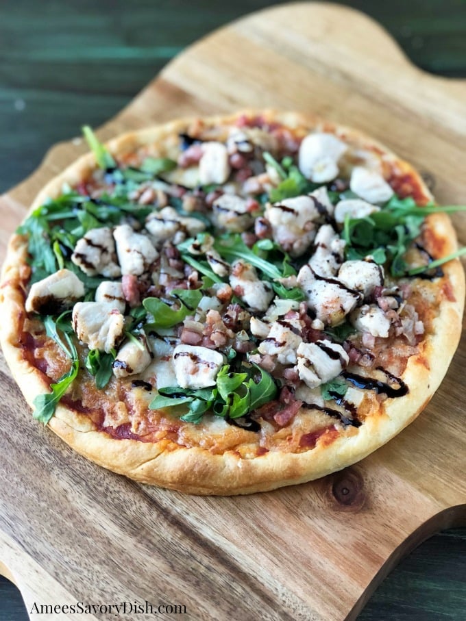 This easy gourmet chicken pizza recipe is made with a premade gourmet crust, baked chicken, fresh arugula, pancetta, and finished with a balsamic glaze. #chickenpizza #homemadepizza #pizzarecipe via @Ameessavorydish