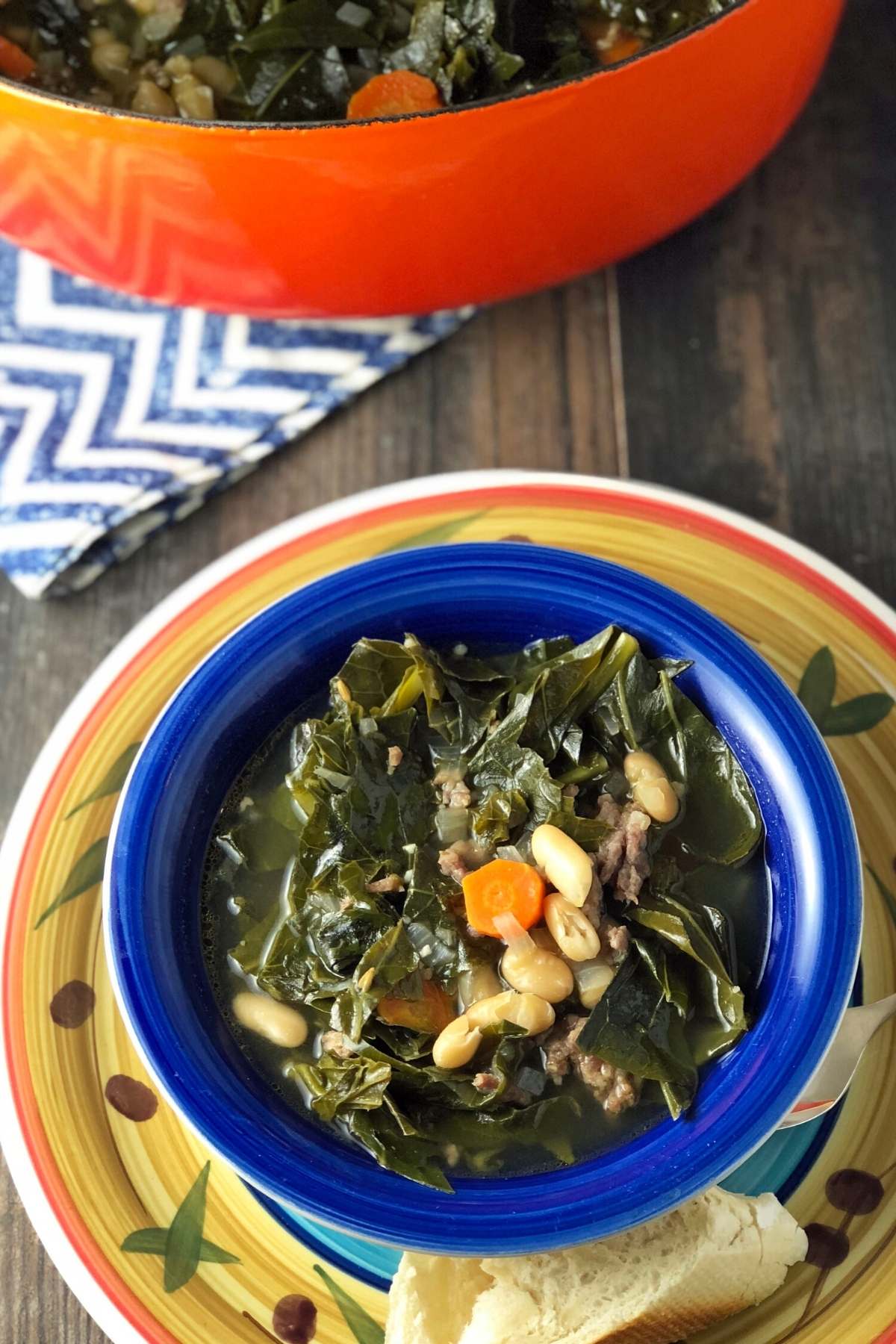 close up of a bowl of soup over a colorful plate with a slice of bread