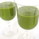 two green smoothies in wine glasses