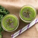 looking down at two green smoothies topped with chia seeds and two straws next to them