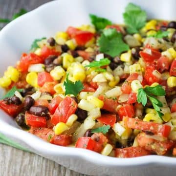 close up of a fiesta corn salad with beans, tomatoes, cilantro and spices