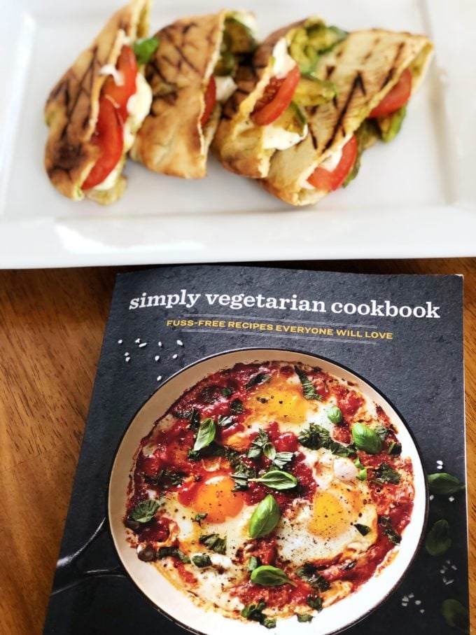 Grilled Caprese pitas on a platter with a cookbook in the foreground