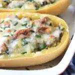 two spaghetti squash halves stuffed with meat and cheese
