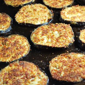close up photo of breaded baked eggplant on a baking sheet