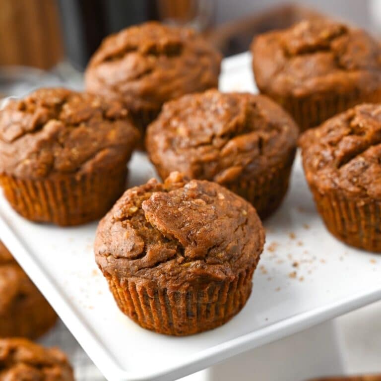eggless banana muffins on a platter with coarse sugar sprinkled around them