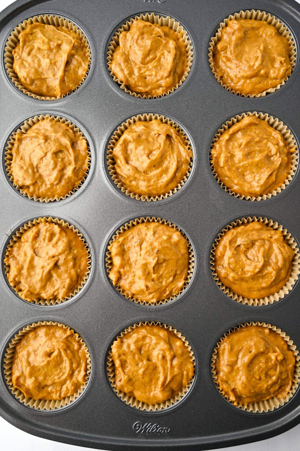 muffin batter in a muffin tin ready to bake