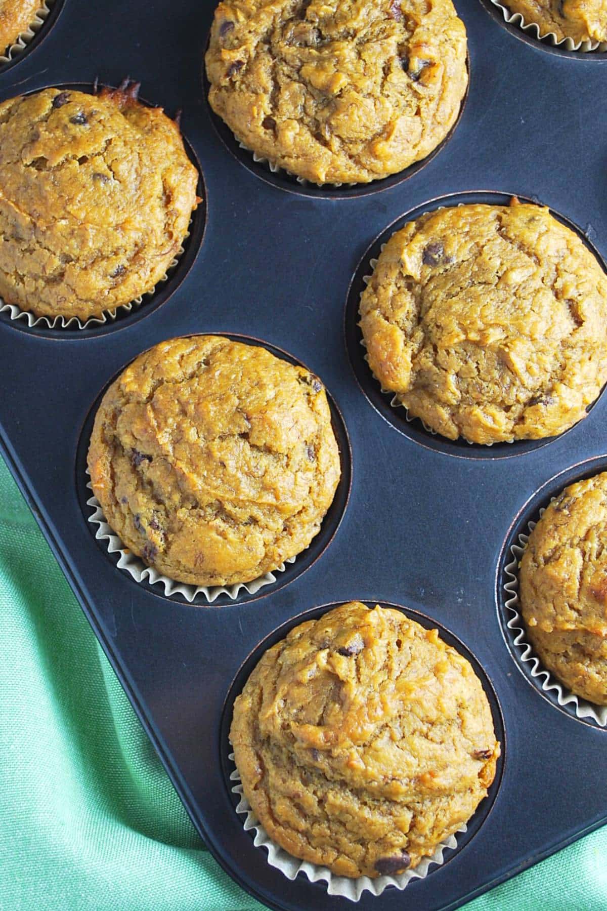 pumpkin banana muffins in a pan with a napkin underneath