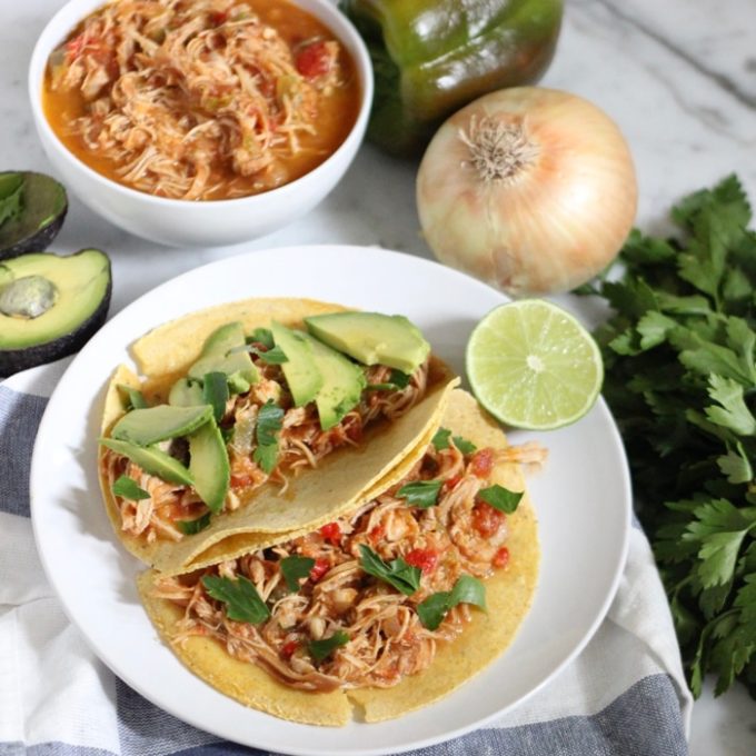 Salsa chicken in tortillas on a plate with bowl of salsa chicken in the background