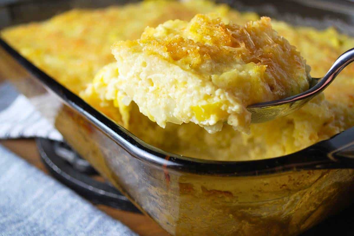 a large serving spoon full of baked squash casserole