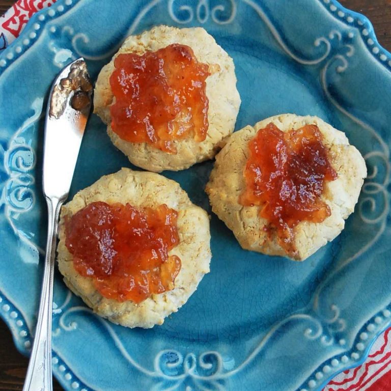 overhead photo of close up photo of 3 cookies on a plate topped with strawberry jam