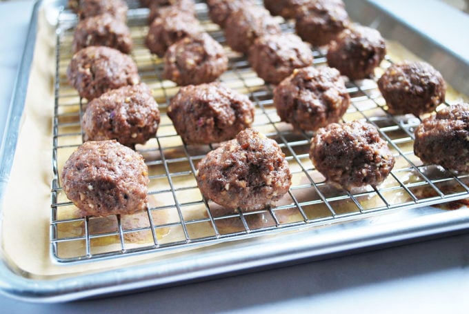 close up photo of cooked meatballs on a baking rack