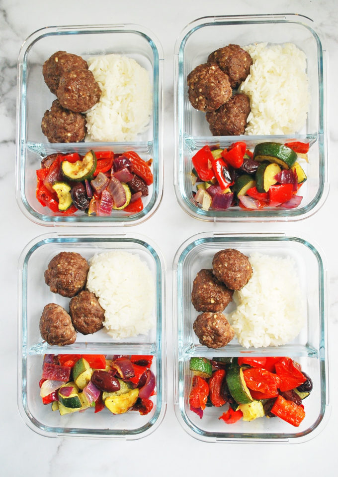 Glass meal prep containers with roasted vegetables, rice, and meatballs
