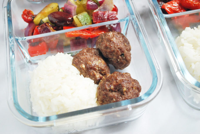 close up of meatballs, rice, and vegetables in a meal prep container