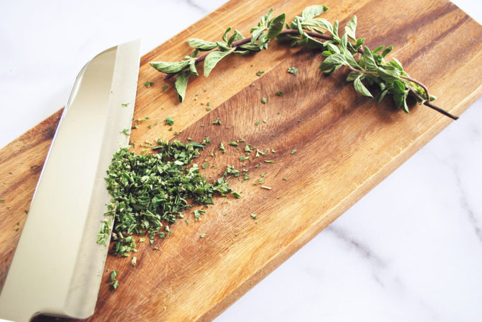 fresh herbs chopped on a wood cutting board