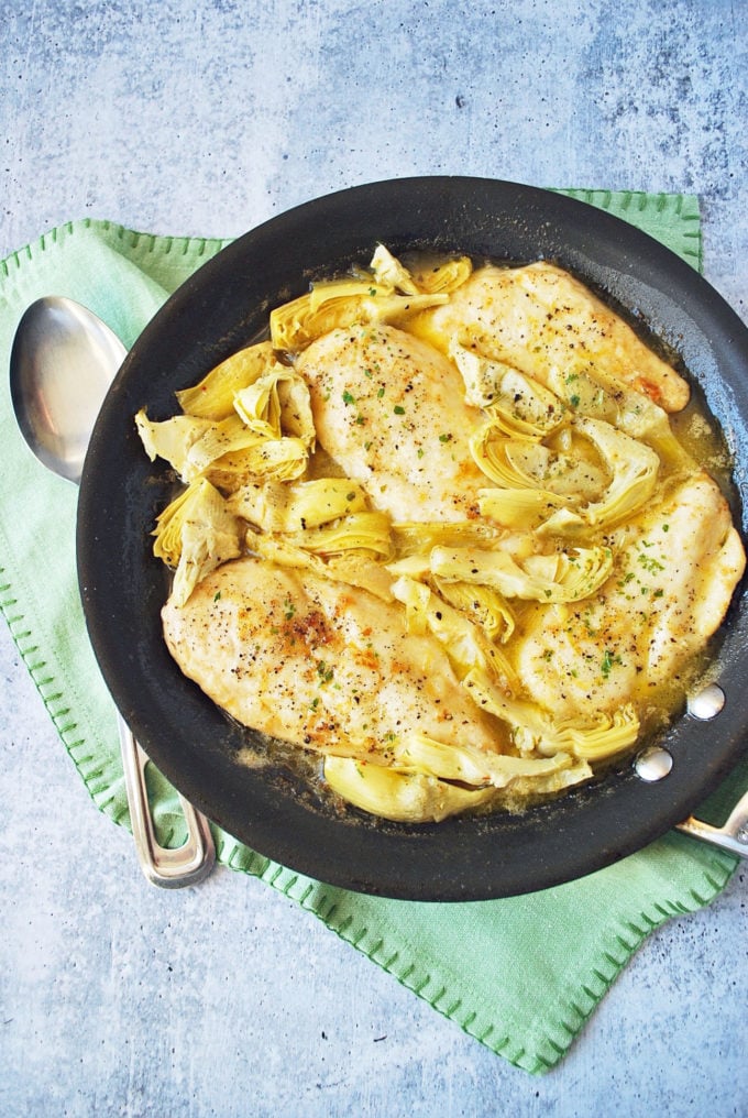 Chicken with artichokes and a lemon sauce in a skillet 