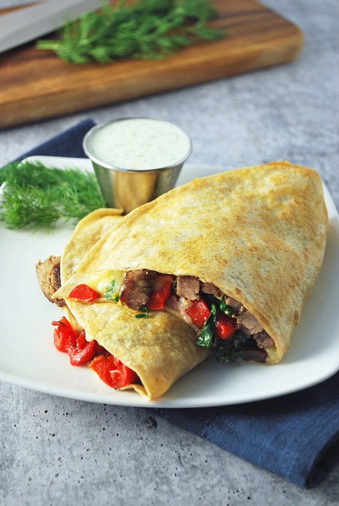 A steak quesadilla cut in half on a plate