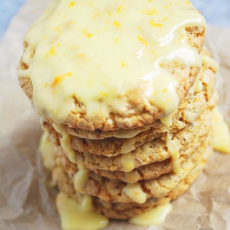 Stack of orange cookies with glaze and zest dripping down