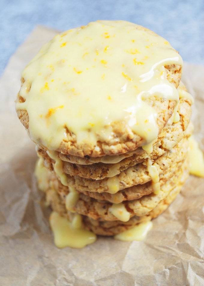 Stack of orange cookies with glaze and zest dripping down