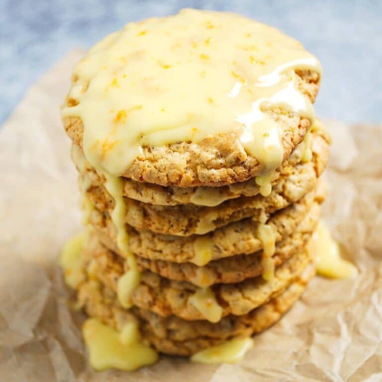 a stack of frosted orange cookies with icing dripping down the sides