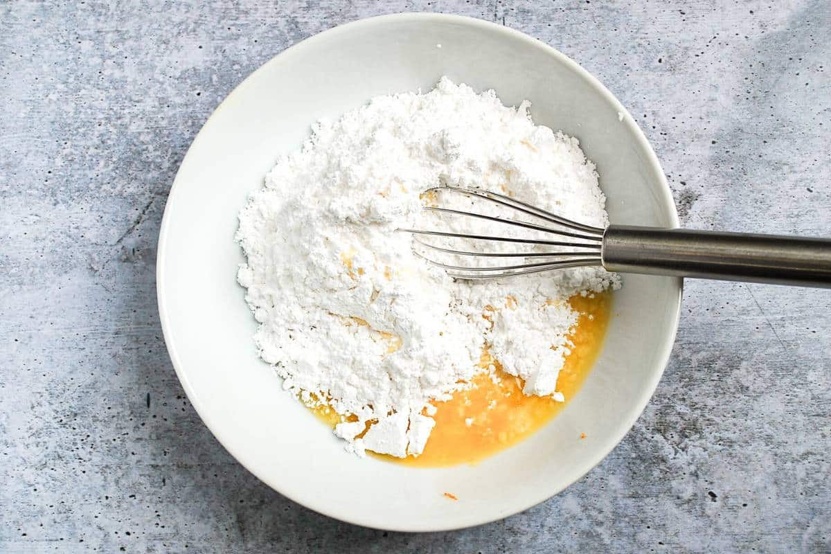 ingredients to mix frosted orange cookie glaze in a bowl
