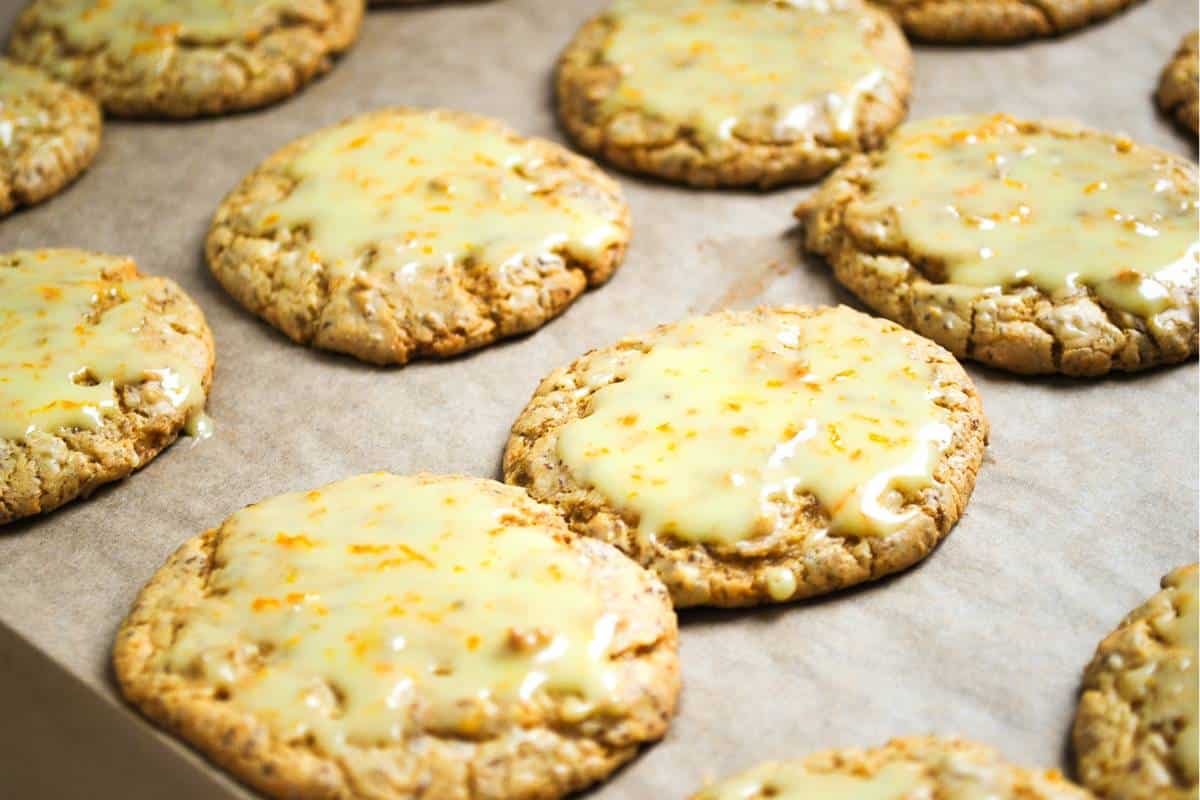 frosted orange cookies on a baking sheet