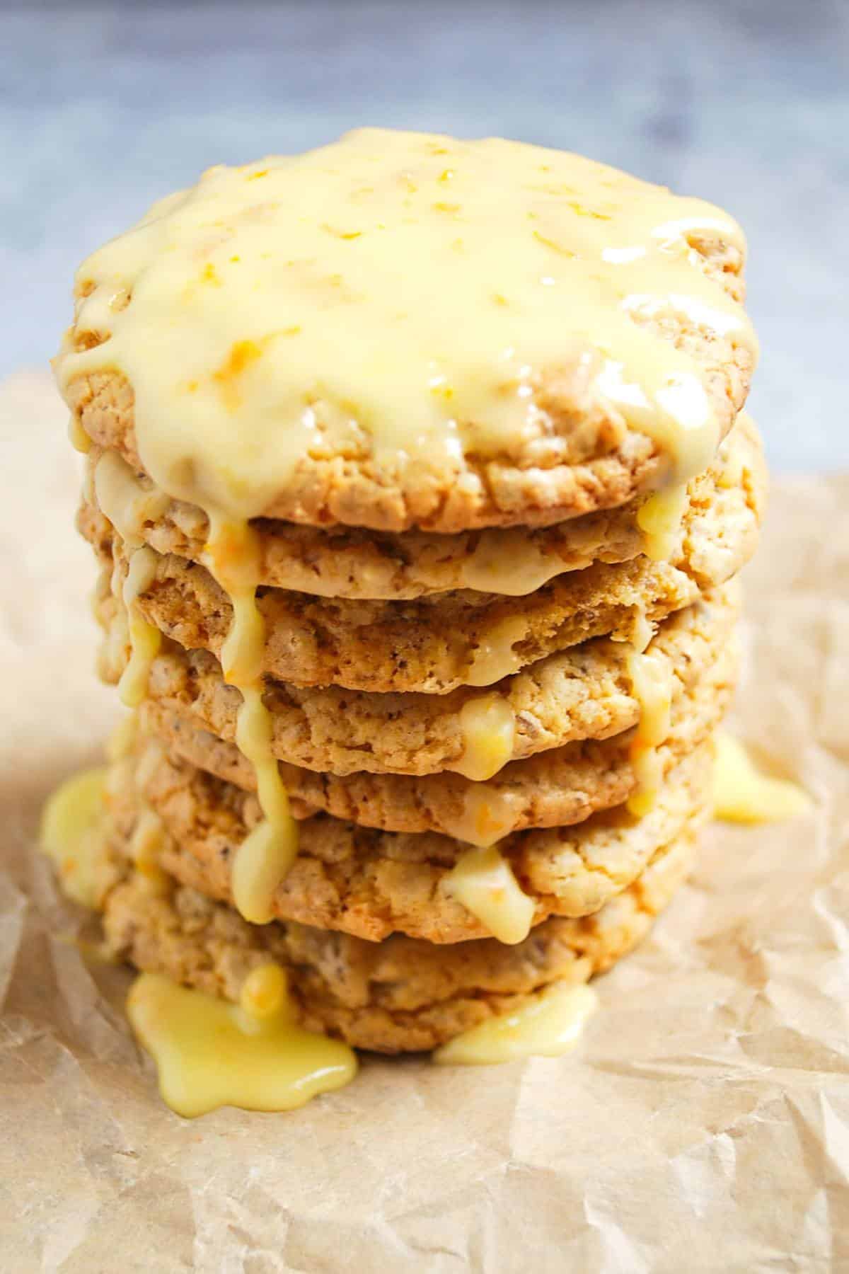 A stack of orange cookies dripping with icing 
