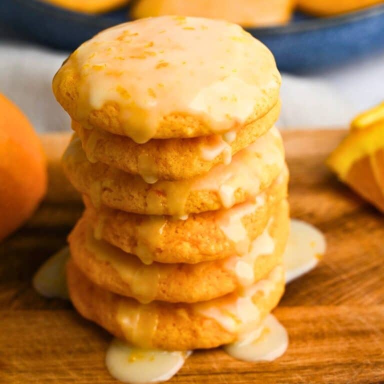 a tall stack of cookies with orange glaze dripping down the sides