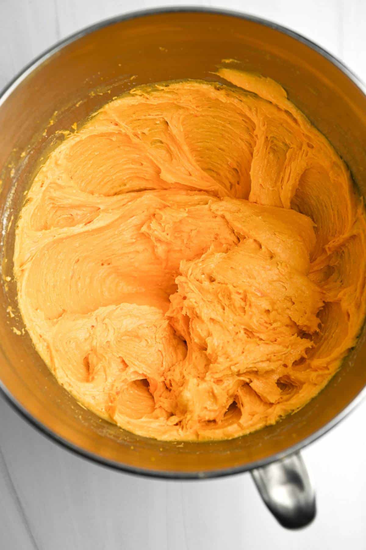 orange cookie batter in a mixing bowl